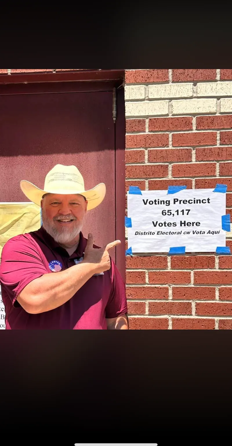 Johnny McCleskey pointing to a Voting Precinct 65 sign in Magnolia, Texas